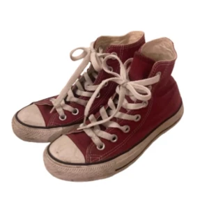 Röda Converse All Star sneakers storlek 36 - Klassiska mörk röda Converse All Star high-top sneakers med vita snören och gummisula. Skorna är i storlek 36, använda fåtal gånger. Sulan är smutsig annars är de i bra skick! Pris kan diskuteras!
