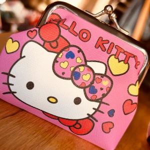 Söt liten portmonä med Hello Kitty-motiv! - Söt liten portmonä i canvas med Hello Kitty-motiv. Mått: 10 x 8 cm. Oanvänd.