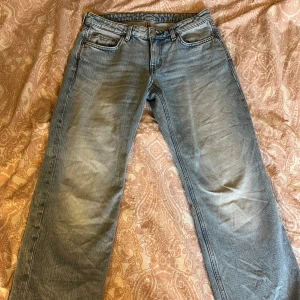Blå Weekday jeans - Säljer ett par blå jeans från Weekday i modellen Arrow Low Straight. Jeansen har klassisk femficksdesign, låg midja och raka ben. Mycket bra skick och inte särskilt mycket använda. Storlek W28 L30