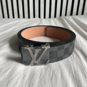 Rutigt bälte - Säljer ett helt oanvänt rutigt bälte. Bältet har ett snyggt silver spänne. Bältet är 115cm långt och har 7 hål. Man får även med en metalbit för att göra fler hål. Priset kan diskuteras.