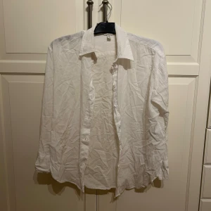 Vit klassisk skjorta i linne material  - Säljer en vit klassisk skjorta i linne material med lång ärm och knappar framtill. I strl S