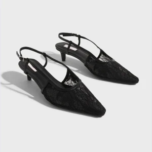 Svarta spetsiga klackar med  spetsdetaljer - Säljer ett par eleganta svarta pumps med spetsig tå och låg klack. Skorna är helt oanvända 