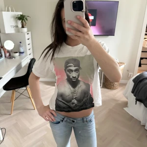 Vit t-shirt med Tupac-tryck - Vit t-shirt med stort tryck av Tupac på framsidan. Den är från Mister Tee. Storlek xs-s