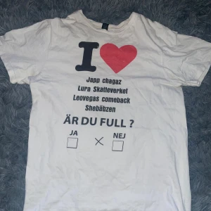 Vit t-shirt med tryck - Vit t-shirt med stort tryck på framsidan i svart och rött. Texten innehåller humoristiska fraser och en stor röd hjärta-grafik. Klassisk passform och rund hals. Perfekt för dig som gillar roliga statement-plagg. Fått många offer på över 600kr tidigare