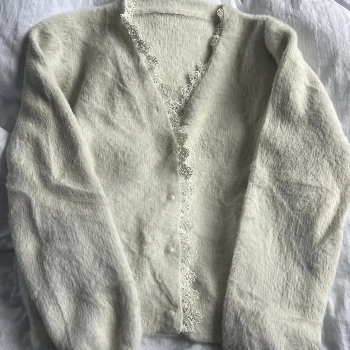 Vit kofta med spetsdetaljer