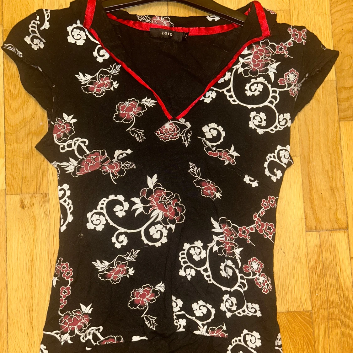 Svart blommig topp med röd kant från Zoio
