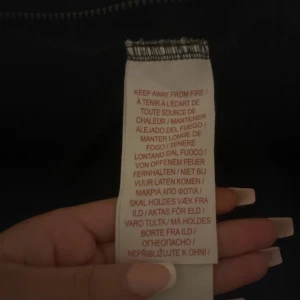 Svart hoodiejacka från Levi's - Svart hoodiejacka från Levi's med dragkedja framtill och huva. Jackan har två fickor och en broderad Levi's-logga på bröstet. Perfekt för en avslappnad stil och enkel att matcha med det mesta.