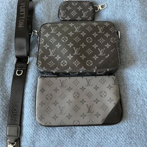Louis Vuitton axelväska med monogram - Säljer en snygg axelväska från Louis Vuitton i svart och grått med klassiskt monogrammönster. Väskan har justerbar axelrem, flera fack och detaljer i skinn. Perfekt för att bära dina viktigaste saker med stil. Riktigt nice till sommaren. Lägg pris förslag 9976 är inte riktiga priset! Vid frågar bara skicka ett meddelande. Tar även byten 