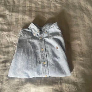 Ljusblå skjorta från Ralph Lauren - En ljusblå skjorta från Ralph Lauren. Helt oanvänd och är i storken 12 år. 