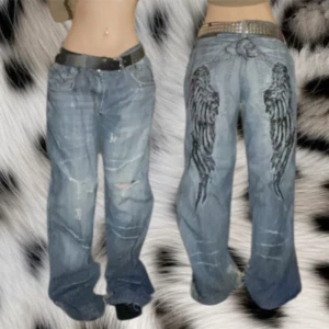Baggy jeans med vingar där bak❤️ - Super coola kosmo lupo jeans med vingar på baksidan❤️tyvärr är de ganska mycker heal bite nedtill på byxorna och jag har sytt igen två hål på kväna men annars är de ingen mer defekt på dom❤️totalledningen:106cm, innerbenslängden:80cm, midjan:46x2cm❤️skriv om du har några frågor😊