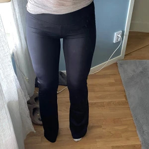 Svarta bootcut leggings - Säljer ett par svarta leggings med bootcut-modell och låg midja. De är stretchiga och sitter tight upptill men har utsvängda ben. Perfekta för en avslappnad och trendig look.