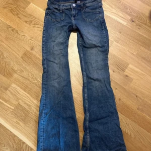 Blå bootcut jeans med låg midja - Säljer ett par klassiska blå jeans med bootcut och låg midja. Perfekta för dig som gillar en retro vibe och vill ha ett par snygga jeans till vardags. 