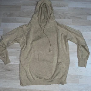 Beige stickad hoodie - Säljer en beige stickad hoodie med luva. Tröjan har långa ärmar och ribbade muddar vid ärmslut och nederkant. Materialet är Merinoull. Perfekt för en avslappnad stil. Storlek XS-S men lutar mer mot S. Skriv gärna vid minsta fråga, pris kan diskuteras.