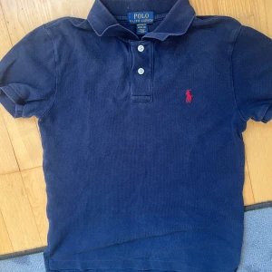 ralph lauren pike blå 10-12 år - säljer denna feta pikeen som passar bra för killar i sommaren, 10-12 år passar väl som xs i manlig storlek. Skicket är bra, tvättad en gång bara. hör av er vid frågor!🤩