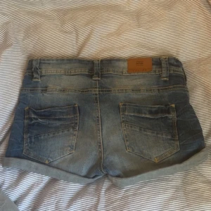 Blå jeansshorts med uppvikta ben - Säljer ett par klassiska blå jeansshorts från Denim med uppvikta ben och femficksmodell. Shortsen har bälteshällor och stängs med dragkedja ocj knapp. Skriv för fler bilder eller frågor!💞💞