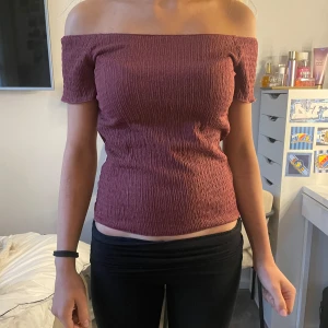 Vinröd offshoulder topp - Säljer en vinröd offshoulder topp med smockad struktur. Toppen är tight och har korta ärmar som sitter nedanför axlarna. Perfekt för dig som gillar en enkel men trendig stil. Kan mötas upp i Storholm❤️