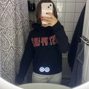 Svart hoodie röd text - Svart hoodie med stor röd och vit text 'UNSTOPPABLE' på bröstet. Klassisk huva med dragsko och långa ärmar. Mjuk insida och ribbade muddar vid ärmslut och nederkant. Perfekt för en avslappnad stil. Från Gina Tricot i storlek xxs.