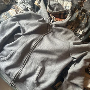 Burberry ziphoodie  - Säljer en grå hoodie med dragkedja och fickor framtill. Huvan är fodrad med klassiskt Burberry-rutigt tyg i beige, svart, rött och vitt. Perfekt för en avslappnad och stilren look. Bra skick, xl men passar lite mindre också 
