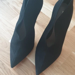 Svarta pumps från Melidith - Eleganta svarta pumps med spetsig tå och hög klack från Melidith. Perfekta för en stilren look.