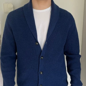Blå stickad kofta från Lawrence Grey - Otrolig fin marinblå stickad kofta från Lawrence grey, skick 10/10 då tröjan är använd ett väldigt få antal gånger. Tröjan är gjord av 30% kaschmir och 70% av Wolle. Tröjan är extremt skön och passar till nästan allt. Vid intresse eller frågor skriv dm.