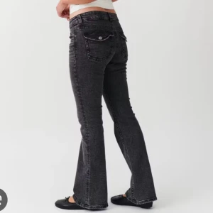 Gina lowwaist jeans - Snygga svarta bootcut jeans med låg midja och klassisk femficksdesign. Perfekta för en avslappnad stil med en touch av retro. Passar bra med både sneakers och klackar. Slitna i slutet av byxorna!