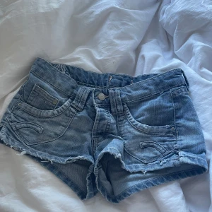 Blå jeansshorts - Säljer ett par snygga blå jeansshorts med fransiga kanter. Använda någon enstaka gång men så snygga! Köpte de second hand, de är från H&M!