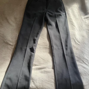 Svarta kostymbyxor från Bik Bok med låg midja - Snygga svarta kostymbyxor från Bik Bok i modellen Vera. Helt nya, aldrig använda. Innerbenslängd: 80 cm Midjemått (tvärs över midjan): 34cm. Nypris: 499kr. Priset går att diskutera!