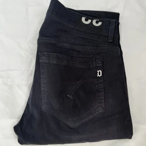 Dondup jeans  - Svarta jeans från dondup modelllen George! Storlek 32. Jeansen har ett hål som jag har sytt ihop ( se bild 4) men det smälter in omärkbart när man har på sig dom.