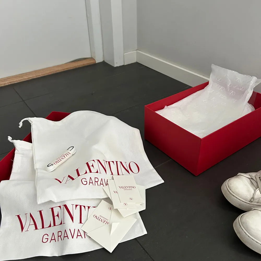 Snygga vita Valentino Garavani sneakers med svarta detaljer. Skorna har en rund tå och snörning, samt de ikoniska nitarna på sidorna. Perfekta för en stilren look är i hyfsat bra skick, nya snören ingår!. Kengät.