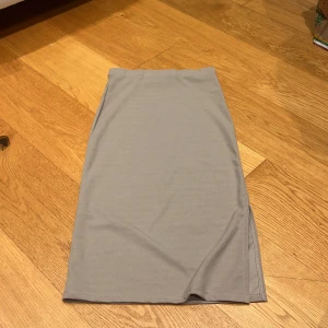 Beige kjol - Snygg beige kjol i en enkel och stilren design. Kjolen har en rak passform och är tillverkad i ett mjukt material. Perfekt för en minimalistisk look. Något kort i storleken, är för kort för mig som är ca 162cm med långa ben.