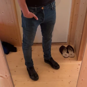 Blå  jeans från Jack & Jones - Säljer ett par extremt fina jeans från Jack and Jones i modellen Glenn, en väldigt populär modell. Notera att Längden är L34 och modellen på bilden har storlek 32 och dessa är snäppet för långa för modellen! Skriv om du har några frågor!