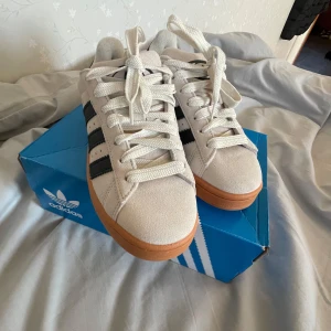 Adidas Campus sneakers - Adidas Campus sneakers i beige med svarta ränder och en brun sula. Dom är helt nya då dom inte passa mig💕1000 kostar dom men säljer för 900,vill sälja så snabbt som möjligt tryck gärna på köp nu💕