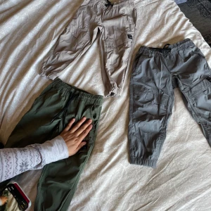 Grå cargopants från 157 - Säljer ett par grå cargopants från 157. Byxorna har elastisk midja och muddar vid bensluten. De har flera praktiska fickor och en dragkedja bak. Perfekta för en avslappnad stil.har tre färger .säg vilken färg vill ni att jag skickar, 