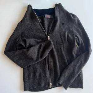 Brun kofta från Morris - Säljer en stilren brun kofta från Morris med dragkedja och ribbade kanter. Koftan är tillverkad i 100% merinoull vilket gör den både mjuk och varm. Perfekt för kyligare dagar.                                        Tröjan är en storlek S men skulle säga att den passar mer som en XS.                                                      Jag har användt den här tröjan en gång men har växt ur den och säljer den för att den inte passar nypris 1200.  