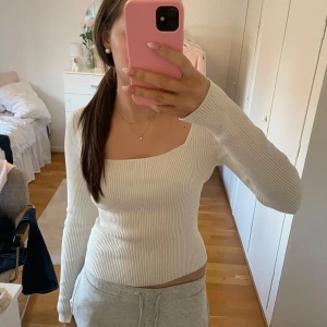 Vit ribbad tröja - En beige ribbad tröja med lång ärm och fyrkantig halsringning. Toppen är från H&M i storlek S med slits i båda armarna