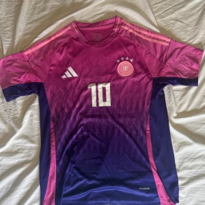 Tyskland em2024 bortaställ Adidas - Tysklands bortaställ i EM 2024. Storlek XL men det är en slim fit så den sitter som en storlek L. Musiala nummer 10 på ryggen. Skriv vid frågor. 