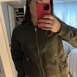 Grön bomberjacka  - Säljer denna så fina bomberjacka i mycket bra skick. Så fin grön färg och perfekt nu till våren! Priset är 150kr plus frakt. 