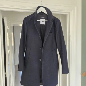 J.Lindeberg rock - Holger Melton modell - size 46/S - Säljer min fina J.Lindeberg rock, modell Holger Melton. Storlek 46, (S-M). Varm & skön, vindtät.   Rocken är i fint skick och sparsamt använd. Säljer p.g.a att den är för liten.   Nypris: 4600 kr.  För mer info: https://www.jlindeberg.com/sv-se/products/holger-melton-coat-jl-navy  Sökord: rock, coat, kappa, vinterjacka, winter jacket