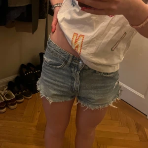 Blå jeansshorts  - Säljer ett par snygga blå jeansshorts. Asnygg sliten kant. Perfekta för sommardagar! 💙står 32 men passar 34