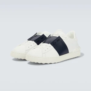 Valentino Garavani sneakers i vitt och blått - Snygga Valentino Garavani sneakers i vitt med en bred blå rem över snörningen. Skorna har en stilren design med rund tå och en bekväm sula. Perfekta för en trendig look.