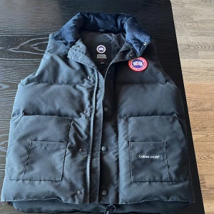 Svart dunväst från Canada Goose - Säljer nu min riktigt snygga canada goose väst. Den är aldrig använd och den säljes för den bara legat i garderoben under ett tag nu. En snygg och varm billig väst som passar dig som är från. 170cm-180cm ungefär. Om ni har frågor är det bara att ställa privat😁