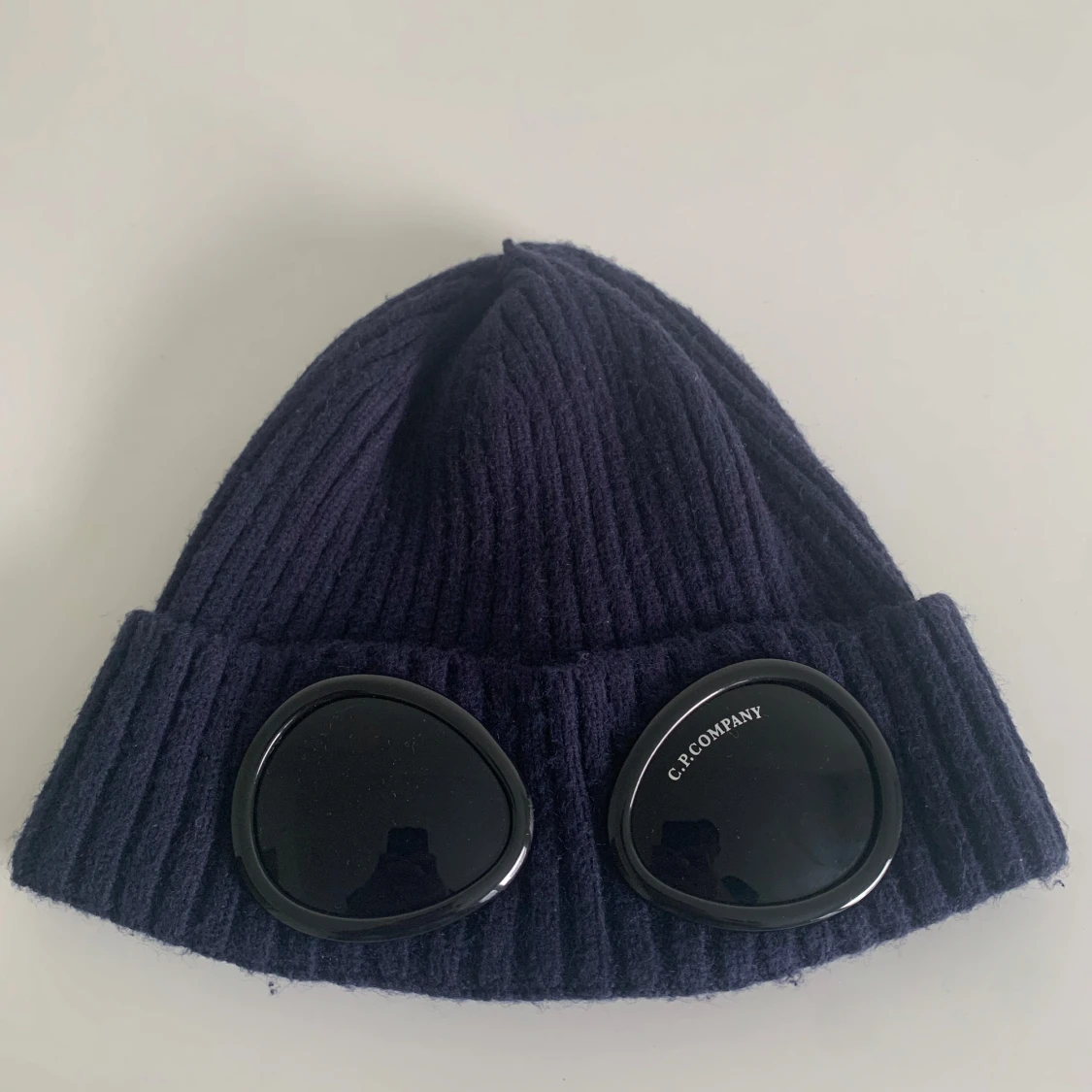 Mörkblå mössa med glasögondetalj från C.P. Company