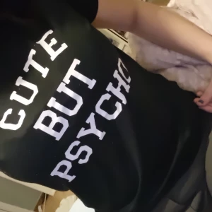 Svart t-shirt med text - Säljer en svart t-shirt med texten 'CUTE BUT PSYCHO' i vita bokstäver. Perfekt för dig som vill ha en t-shirt med attityd. Passar till både jeans och kjol. 🖤