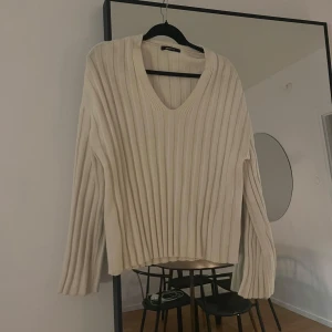 Beige ribbad tröja med v-ringning - Säljer en stilren ljusbeige/vit stickad tröja med v-ringning och ribbad design. 🤍