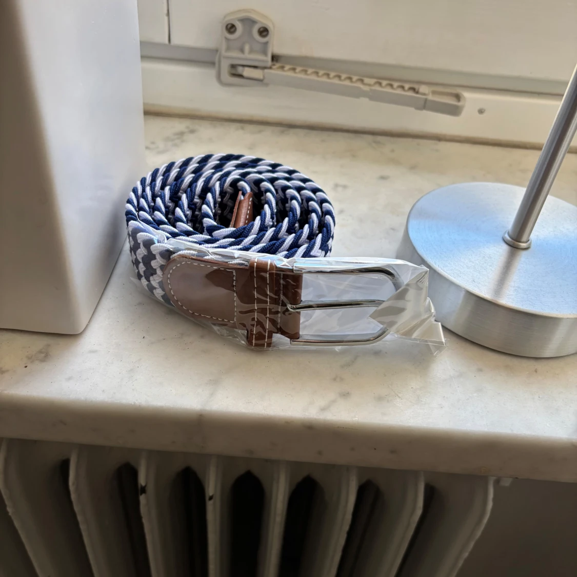 Randigt bälte med läderdetaljer