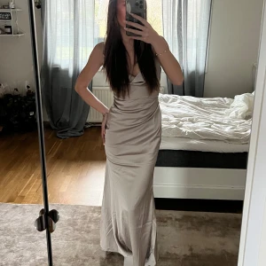 Champagnefärgad satinklänning - Lång champagnefärgad klänning i satin. Perfekt som bla balklänning! Ej använd, endast provad. Nypris 750kr.💝