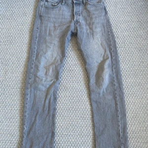 Grå jeans från Jack & Jones - Snygga grå jeans från Jack & Jones med en klassisk design. De har en slim passform och är tillverkade i ett bekvämt denimtyg. Perfekta för en stilren look.