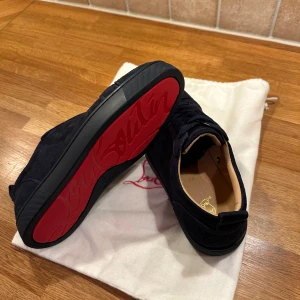 Louboutin, marinblå - Snygga svarta sneakers från Christian Louboutin. använd en gång. Pris går att diskuteras😀Tveka inte på att hörs av dig.