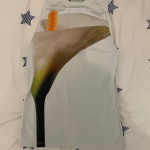 Blommig ärmlös topp från Zara - Säljer en stilren ärmlös topp från Zara med ett stort blommotiv i mjuka färger. Perfekt för varma dagar eller som ett lager under en jacka. Toppen har en modern design och är tillverkad i ett lätt material.