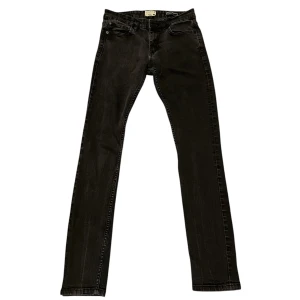 Svarta jeans - Snygga svarta jeansbyxor med en slim straight passform. De har en klassisk design med fem fickor och knappgylf. Perfekta för en stilren look.